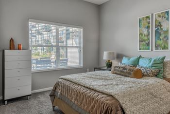 a bedroom with a bed and a large window